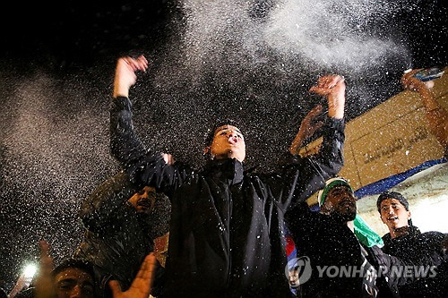 15일(현지시간) 저녁 팔레스타인 가자지구 남부 칸유니스에서 청년들이 휴전 합의 소식을 반기고 있다.   [로이터 연합뉴스]